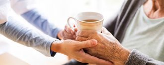 Handing a cup of tea to an elderly lady