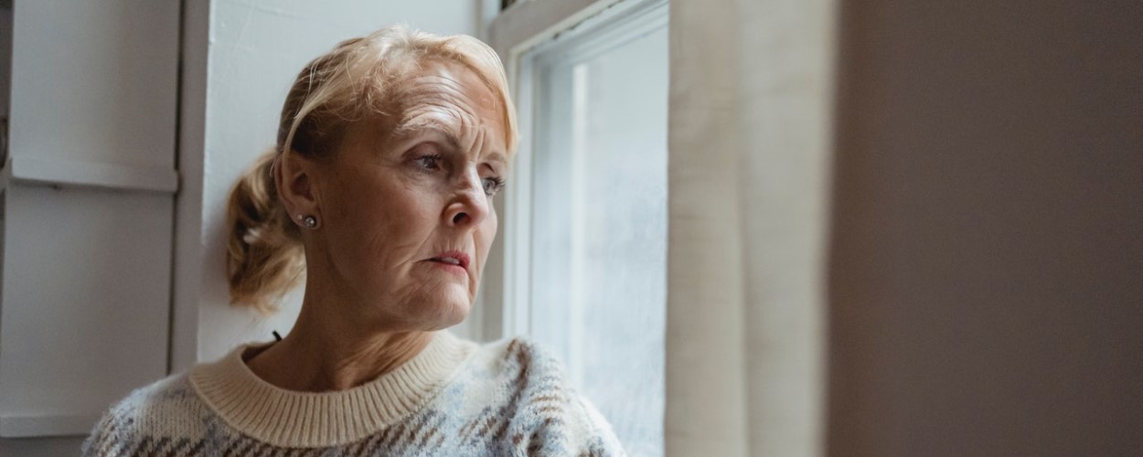Older woman looking through window