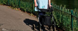 elderly person with walking frame, an example of mobility aids